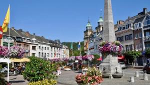 a city street with flowers and a monument in the middle at The Kiosk in Malmedy