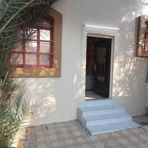 a door to a house with stairs and a window at العين الهيلي مصباح بيت14 in Al Ain