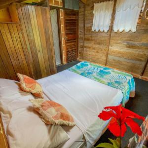 2 camas en una habitación con paredes de madera en Casa por temporada a 250mts da praia, en Santa Cruz Cabrália
