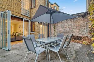 stół z krzesłami i parasol na patio w obiekcie Tranquil Apartment Southwark w Londynie