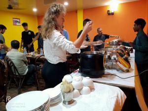 a woman standing in front of a table with eggs at THE MYSTIC FOREST-A TEA GARDEN RESORT in Mādāri Hāt