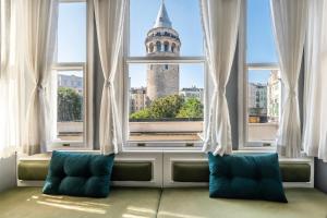 a room with a window with a view of a tower at Historical Apt. with Galata Sea View/Turkish Hamam in Istanbul