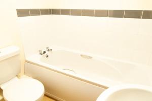 a bathroom with a white tub and a toilet at *New* 2-Bed Modern Apartment in Burton upon Trent