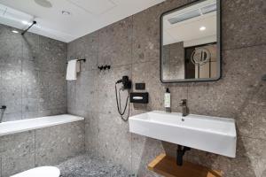 a bathroom with a sink and a mirror at Qubus Hotel Katowice in Katowice