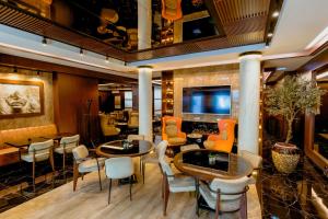 贝尔格莱德Nobel Gallery Hotel的有桌椅和电视的餐厅