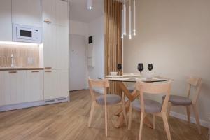 a kitchen and dining room with a table and chairs at Apartament Premium PINEA 107 in Pobierowo
