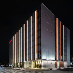 a large building with a lit up facade at night at Qubus Hotel Katowice in Katowice