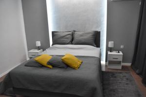 a bedroom with a large bed with two yellow pillows at BeLux apartment in Niš