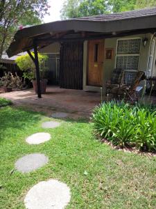 a patio with awning and chairs on a house at Riverbush Lodge Guesthouse in Parys