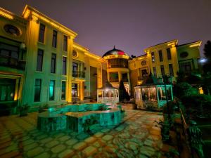 un grand bâtiment avec une fontaine devant lui dans l'établissement Manor Luxury Hotel Baku, à Baku