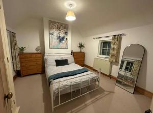 - une chambre avec un lit et un miroir dans l'établissement 1 Appletree Cottages, Hot Tub, 