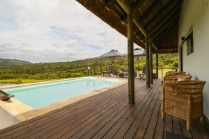 a wooden deck with a swimming pool on a house at Barefoot Addo Elephant Lodge - Luxury Family Villa in Addo