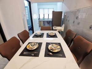 a dining room with a table with dishes on it at 6-11pax Brand New! 5 Mins Sunway Pyramid l Netflix in Petaling Jaya
