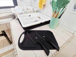 a black cutting board sitting on a counter next to a sink at 6-11pax Brand New! 5 Mins Sunway Pyramid l Netflix in Petaling Jaya