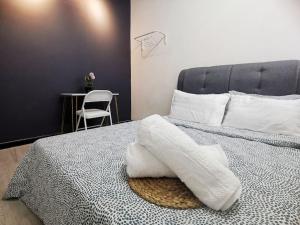 Un dormitorio con una cama con toallas blancas. en 6-11pax Brand New! 5 Mins Sunway Pyramid l Netflix, en Petaling Jaya