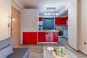 a kitchen with red cabinets and a table at Fantastic sea view one-bedroom apartment - Lagonissi in Lagonissi +21 photos
