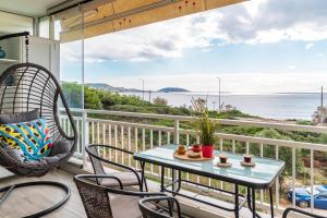 uma varanda com mesa e cadeiras e vista para o oceano em Fantastic sea view one-bedroom apartment - Lagonissi em Lagonissi