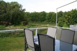 una mesa y sillas en un balcón con vistas en Schorrebloem 21*, en Nieuwvliet