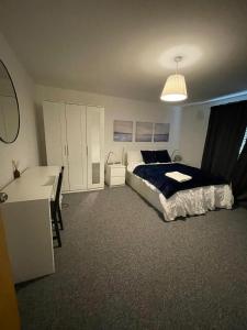 a bedroom with a bed and a desk in it at Woolwich 2Bedroom Apartment in London