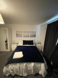 a bedroom with a large bed and two night stands at Woolwich 2Bedroom Apartment in London