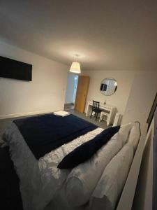 ein Schlafzimmer mit einem großen Bett und einem Tisch in der Unterkunft Woolwich 2Bedroom Apartment in London