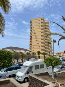 a rv parked in a parking lot in front of a tall building at Achacay View Apartment in Los Cristianos