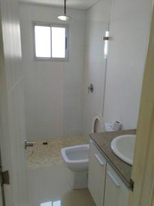 La salle de bains blanche est pourvue de toilettes et d'un lavabo. dans l'établissement Lindo apartamento con excelente vista Bahía, à Carthagène des Indes