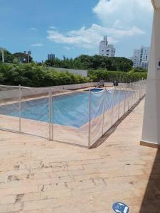 une clôture autour d'une piscine dans un bâtiment dans l'établissement Lindo apartamento con excelente vista Bahía, à Carthagène des Indes