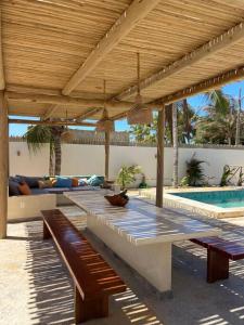 une terrasse avec une table, un canapé et une piscine dans l'établissement Vila KitePirosca, à Fortim
