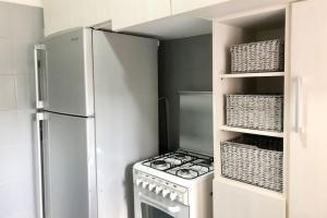 a white kitchen with a stove and a refrigerator at Lovely 2 Bedroom in Gemmayze in Beirut