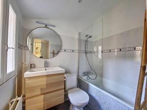 a bathroom with a toilet and a sink and a mirror at Le TouCan - 100m Palais et Pont in Avignon