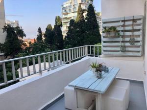 een balkon met een houten bank en een tafel bij Lovely 2 Bedroom in Gemmayze in Beiroet