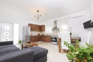 a living room with a couch and a kitchen at Contessa Caterina in Karousádes