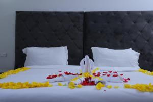 a bed with a stuffed animal on it with flowers on it at Trinity Hotel in Addis Ababa