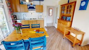 eine Küche mit einem Holztisch und blauen Stühlen in der Unterkunft Grüntal-Residenz Haus III App. 4 in Grömitz