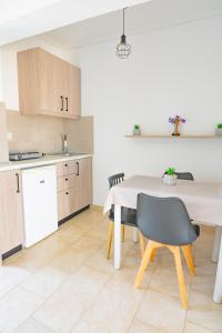 a kitchen and dining room with a table and chairs at Anthia Apartments in Marmari