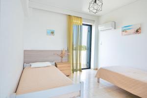 a bedroom with two beds and a window at Anthia Apartments in Marmari