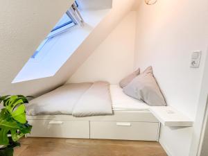 a white bed in a room with a window at Modernes Apartment in Diepholz in Diepholz