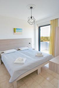 a bedroom with a large bed with two towels on it at Anthia Apartments in Marmari