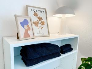 - une étagère blanche avec des serviettes et une lampe dans l'établissement Modernes Apartment in Diepholz, à Diepholz