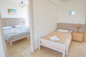 a bedroom with two beds and a mirror at Anthia Apartments in Marmari