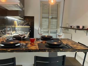 een keuken met een tafel met borden en wijnglazen bij La casa di Eva e Zoe in Albano Laziale