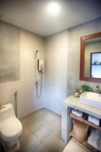 een badkamer met een douche, een toilet en een wastafel bij Beautiful Modern Garden Home in Kampot