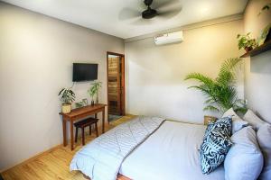 a bedroom with a bed and a desk and a tv at Beautiful Modern Garden Home in Kampot
