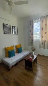 een woonkamer met een bank en een tafel bij Home Tales 275 by Tipiverse in Bangalore