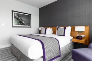 Pokój hotelowy z dużym łóżkiem i krzesłem w obiekcie Crowne Plaza Newcastle - Stephenson Quarter, an IHG Hotel w mieście Newcastle upon Tyne