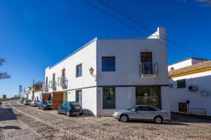 two cars parked in front of a white building at Casa Xanadu Carmona - Stylish villa with rooftop terrace and stunning views of Parador in Carmona +59 photos