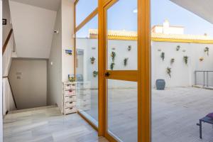 a pivot door in a room with a balcony at Casa Xanadu Carmona - Stylish villa with rooftop terrace and stunning views of Parador in Carmona