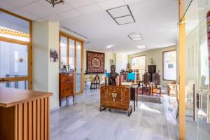 a living room with a table and chairs in it at Casa Xanadu Carmona - Stylish villa with rooftop terrace and stunning views of Parador in Carmona