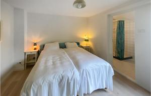 een wit bed in een slaapkamer met 2 lampen op een tafel bij Amazing Home In Bergen Aan Zee With Wifi in Bergen aan Zee